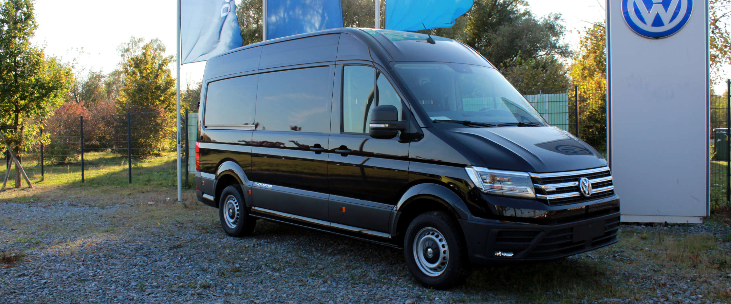 VW Crafter in schwarz, mit VW Logosäule