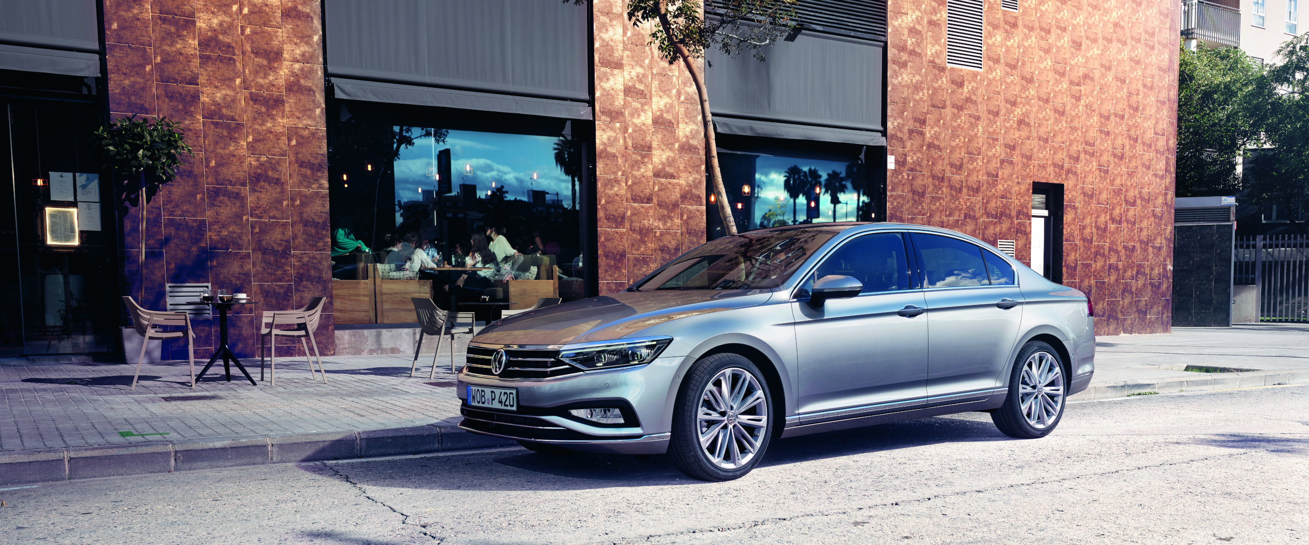VW Passat Limousine steht vor einem Café
