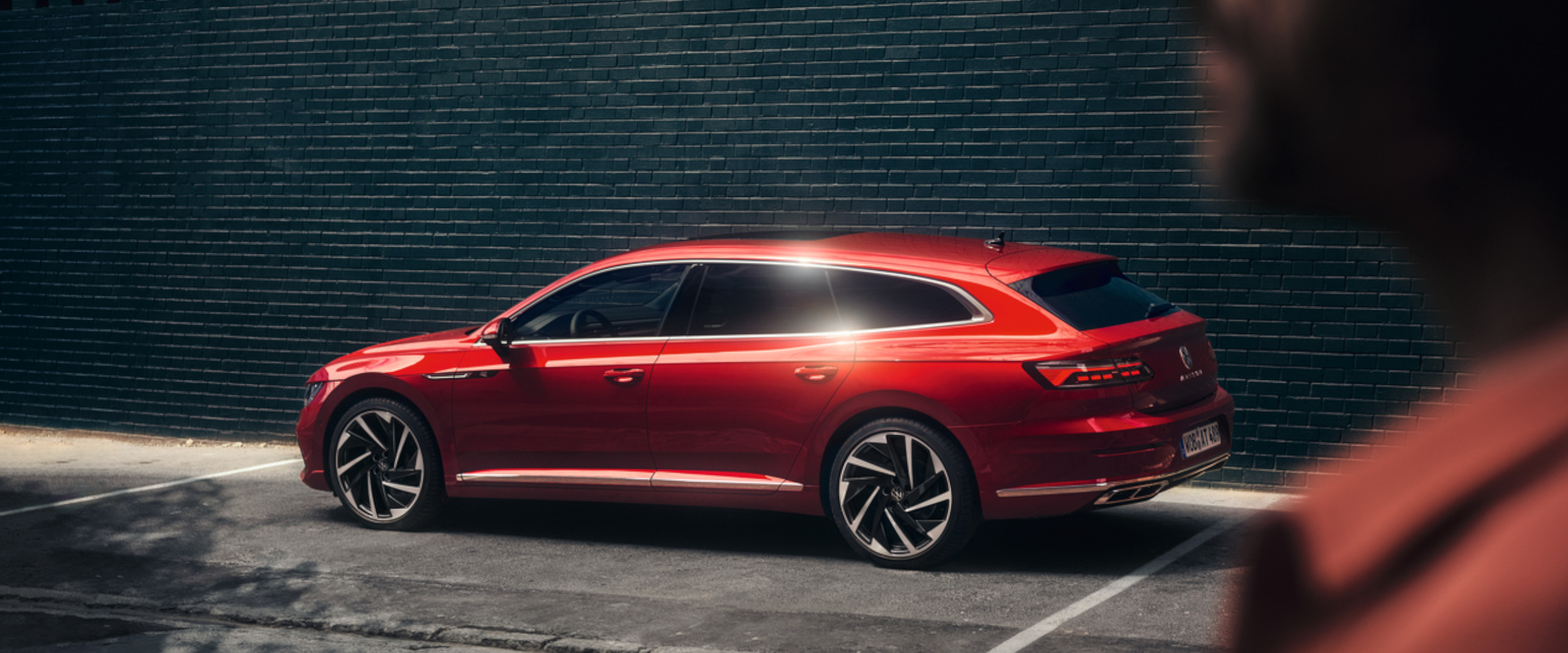 Ein roter Arteon Shooting Brake steht auf einem Parkplatz